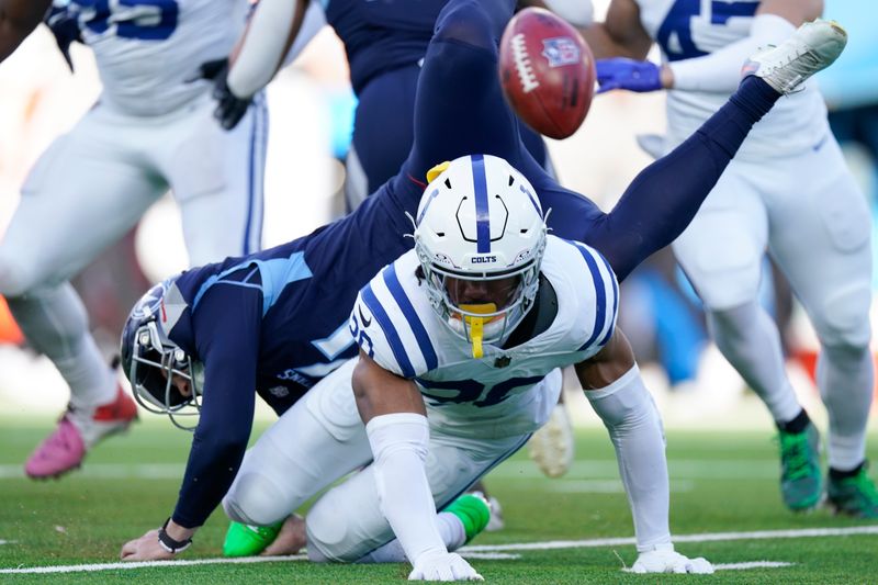 Tennessee Titans punter Ryan Stonehouse, right, flips over Indianapolis Colts safety Nick Cross (20) after a blocked punt during the second half of an NFL football game Sunday, Dec. 3, 2023, in Nashville, Tenn. (AP Photo/George Walker IV)