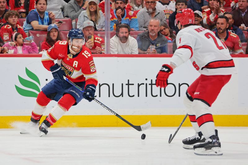 May 26, 2025; Sunrise, Florida, USA; Florida Panthers left wing Matthew Tkachuk (19) and Carolina Hurricanes defenseman Alexander Nikishin (21) battle for the puck during the second period in game four of the Eastern Conference Final of the 2025 Stanley Cup Playoffs at Amerant Bank Arena. Mandatory Credit: Sam Navarro-Imagn Images