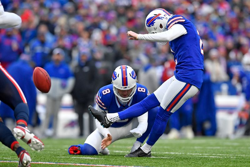 Buffalo Bills place kicker Tyler Bass (2) kicks a field goal with Sam Martin (8) holding during the first half of an NFL football game against the New England Patriots in Orchard Park, N.Y., Sunday, Dec. 31, 2023. (AP Photo/Adrian Kraus)