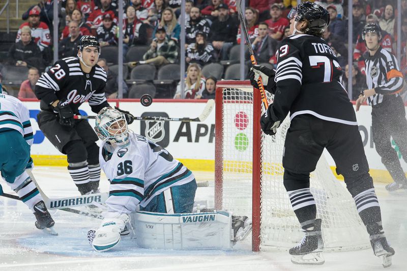 Dec 1, 2023; Newark, New Jersey, USA; San Jose Sharks goaltender Kaapo Kahkonen (36) looks back at the puck in front of New Jersey Devils right wing Tyler Toffoli (73) and right wing Timo Meier (28) during the second period at Prudential Center. Mandatory Credit: Vincent Carchietta-USA TODAY Sports