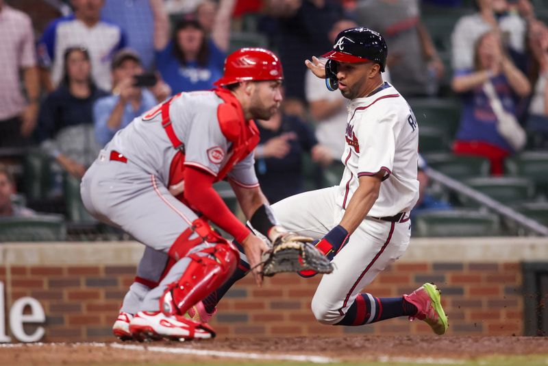 May 8, 2025; Atlanta, Georgia, USA; Atlanta Braves outfielder Eddie Rosario (9) scores a run past Cincinnati Reds catcher Austin Wynns (38) in the ninth inning at Truist Park. Mandatory Credit: Brett Davis-Imagn Images
