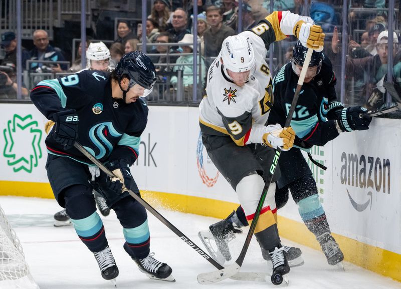 Nov 8, 2024; Seattle, Washington, USA;  Vegas Golden Knights forward Jack Eichel (9) battles Seattle Kraken forward Chandler Stephenson (9) and defenseman Brandon Montour (62) for the puck during the third period at Climate Pledge Arena. Mandatory Credit: Stephen Brashear-Imagn Images