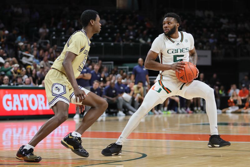 Feb 24, 2024; Coral Gables, Florida, USA; Miami Hurricanes guard Wooga Poplar (5) protects the basketball from Georgia Tech Yellow Jackets guard Kowacie Reeves Jr. (14) during the second half at Watsco Center. Mandatory Credit: Sam Navarro-USA TODAY Sports