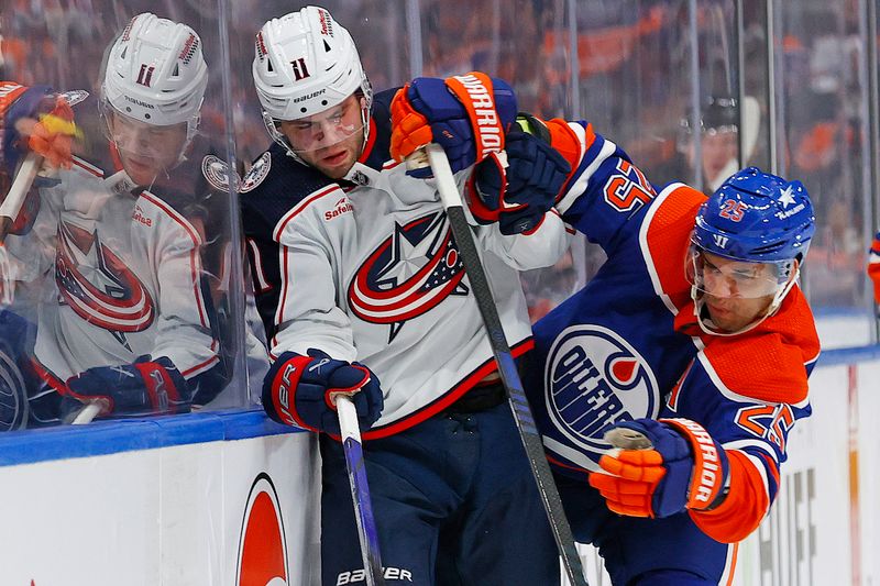 Jan 23, 2024; Edmonton, Alberta, CAN; Edmonton Oilers defensemen Darnell Nurse (25) checks Columbus Blue Jackets forward Adam Fantilli (11) during the second period at Rogers Place. Mandatory Credit: Perry Nelson-USA TODAY Sports