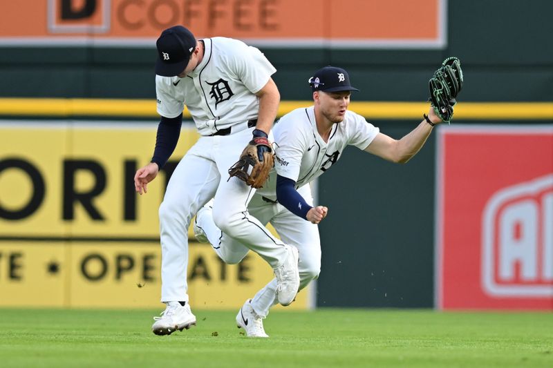Sep 11, 2024; Detroit, Michigan, USA; Detroit Tigers second baseman Colt Keith (33) ducks out of the way of center fielder Parker Meadows (22) to avoid a collision as Meadows ran in to catch a shallow fly ball behind second base against the Colorado Rockies in the first inning at Comerica Park. Mandatory Credit: Lon Horwedel-Imagn Images