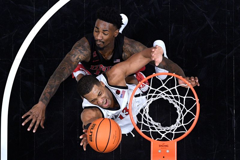 Jan 6, 2024; San Diego, California, USA; San Diego State Aztecs forward Jaedon LeDee (13) goes to the basket defended by UNLV Rebels forward Kalib Boone (10) during the first half at Viejas Arena. Mandatory Credit: Orlando Ramirez-USA TODAY Sports