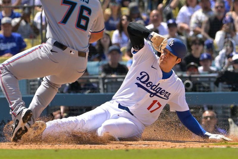 Apr 30, 2025; Los Angeles, California, USA;  Los Angeles Dodgers designated hitter Shohei Ohtani (17) beats the tag by Miami Marlins relief pitcher Luarbert Arias (76) scoring on a wild pitch in the eighth inning at Dodger Stadium. Mandatory Credit: Jayne Kamin-Oncea-Imagn Images