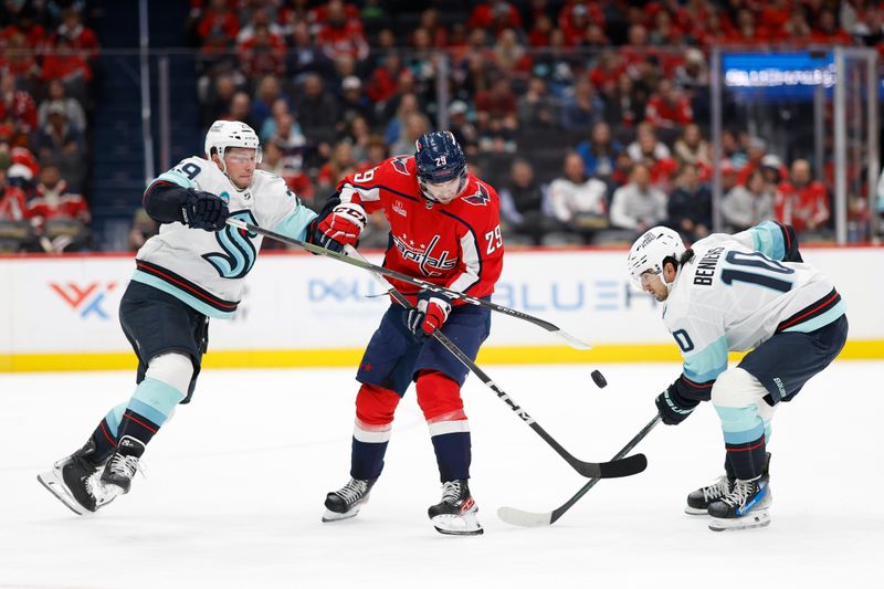 Jan 11, 2024; Washington, District of Columbia, USA; Washington Capitals center Hendrix Lapierre (29) battles for the puck with Seattle Kraken defenseman Vince Dunn (29) and Kraken center Matty Beniers (10) in the first period at Capital One Arena. Mandatory Credit: Geoff Burke-USA TODAY Sports