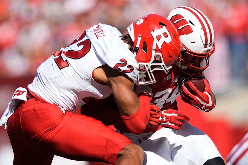 Oct 7, 2023; Madison, Wisconsin, USA;  Wisconsin Badgers running back Jackson Acker (34) is pushed out of bounds by Rutgers Scarlet Knights linebacker Tyreem Powell (22) during the second quarter at Camp Randall Stadium. Mandatory Credit: Jeff Hanisch-USA TODAY Sports
