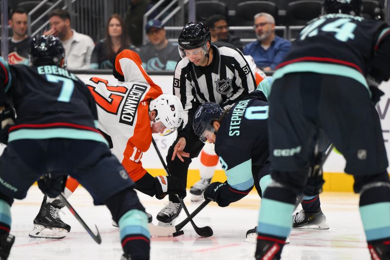 Oct 17, 2024; Seattle, Washington, USA; Philadelphia Flyers center Jett Luchanko (17) and Seattle Kraken center Chandler Stephenson (9) face-off during the second period at Climate Pledge Arena. Mandatory Credit: Steven Bisig-Imagn Images