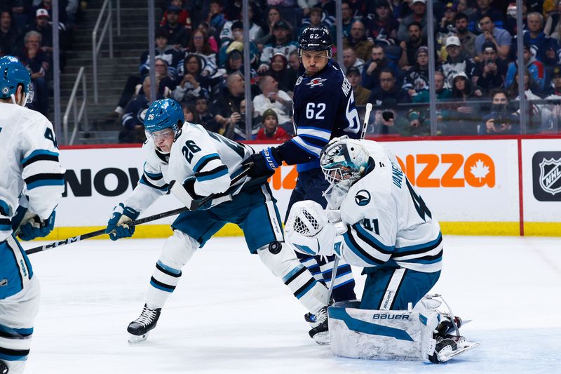 Feb 24, 2025; Winnipeg, Manitoba, CAN;  San Jose Sharks goalie Vitek Vanecek (41) makes a save as Winnipeg Jets forward Nino Niederreiter (62) and San Jose Sharks defenseman Jack Thompson (26) look for a rebound during the second period at Canada Life Centre. Mandatory Credit: Terrence Lee-Imagn Images