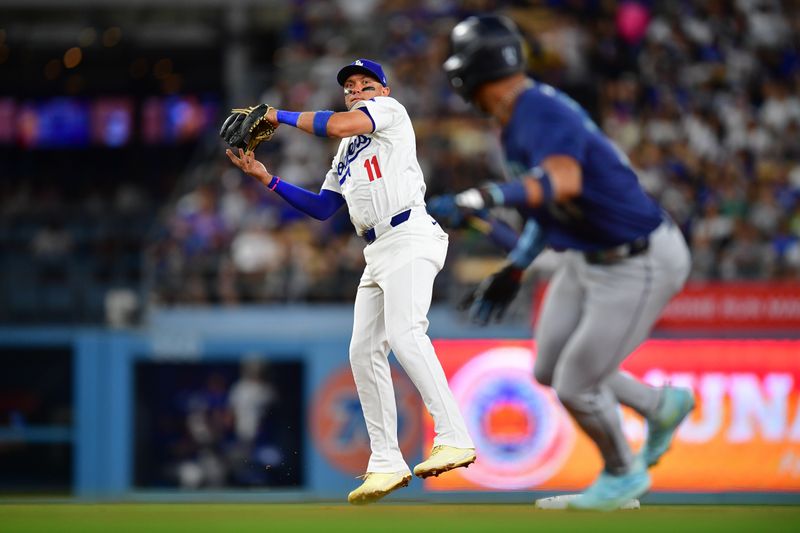 Aug 19, 2024; Los Angeles, California, USA; Los Angeles Dodgers shortstop Miguel Rojas (11) runs after Seattle Mariners designated hitter Julio Rodríguez (44) during the seventh inning at Dodger Stadium. Mandatory Credit: Gary A. Vasquez-USA TODAY Sports