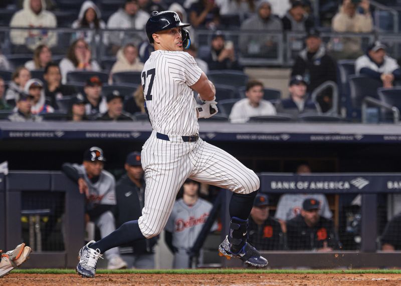 May 3, 2024; Bronx, New York, USA; New York Yankees designated hitter Giancarlo Stanton (27) hits an RBI double during the ninth inning against the Detroit Tigers at Yankee Stadium. Mandatory Credit: Vincent Carchietta-USA TODAY Sports