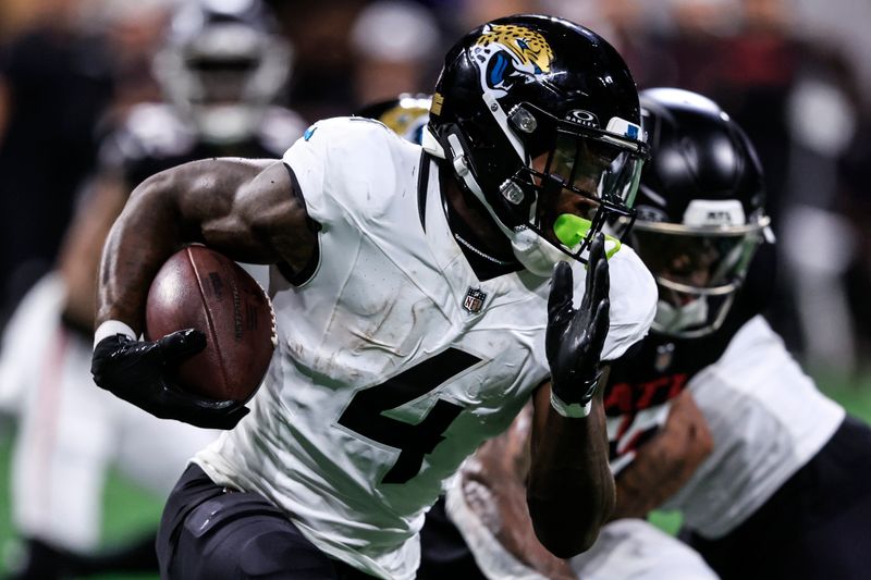 Jacksonville Jaguars running back Tank Bigsby (4) runs against the Atlanta Falcons in the first half of an NFL preseason footballl game, Friday, Aug. 23, 2024, in Atlanta. (AP Photo/Butch Dill)