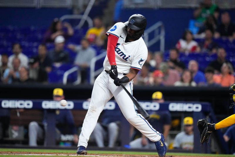 May 22, 2024; Miami, Florida, USA; Miami Marlins first base Josh Bell (9) hits a single against the Milwaukee Brewers during the fourth inning at loanDepot Park. Mandatory Credit: Rich Storry-USA TODAY Sports