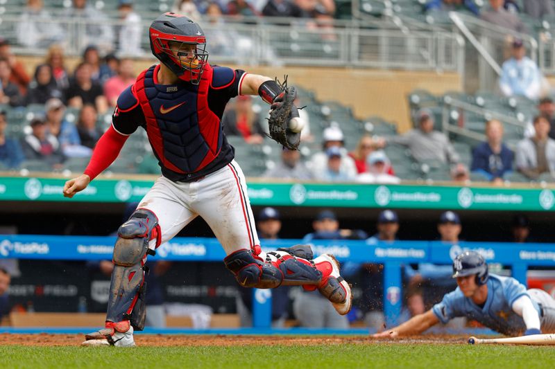 Jun 20, 2024; Minneapolis, Minnesota, USA; Minnesota Twins catcher Ryan Jeffers (27) catches the throw as Tampa Bay Rays shortstop Taylor Walls (6) scores on a single by left fielder Jonny DeLuca (not pictured) in the tenth inning at Target Field. Mandatory Credit: Bruce Kluckhohn-USA TODAY Sports