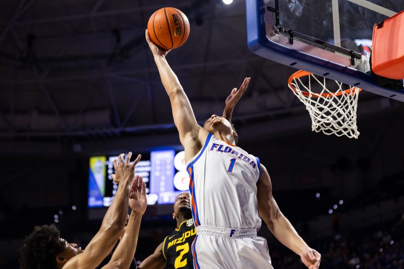 Feb 28, 2024; Gainesville, Florida, USA; Florida Gators guard Walter Clayton Jr. (1) grabs a rebound over Missouri Tigers guard Tamar Bates (2) during the first half at Exactech Arena at the Stephen C. O'Connell Center. Mandatory Credit: Matt Pendleton-USA TODAY Sports