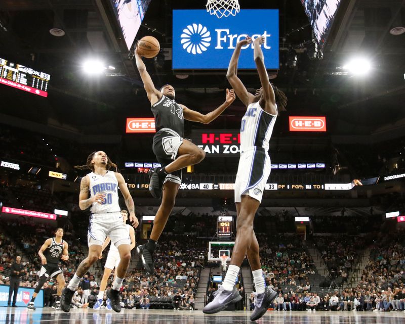 SAN ANTONIO, TX - MARCH 14:  Blake Wesley #14 of the San Antonio Spurs dunks past Bol Bol #10 of the Orlando Magic in the first half at AT&T Center on March 14, 2023 in San Antonio, Texas. NOTE TO USER: User expressly acknowledges and agrees that, by downloading and or using this photograph, User is consenting to terms and conditions of the Getty Images License Agreement. (Photo by Ronald Cortes/Getty Images)