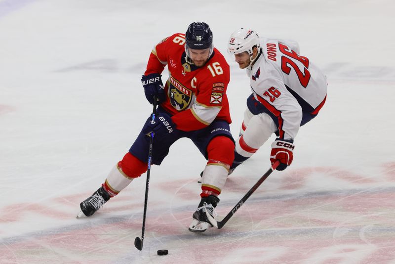 Nov 25, 2024; Sunrise, Florida, USA; Florida Panthers center Aleksander Barkov (16) moves the puck ahed of Washington Capitals center Nic Dowd (26) during the third period at Amerant Bank Arena. Mandatory Credit: Sam Navarro-Imagn Images