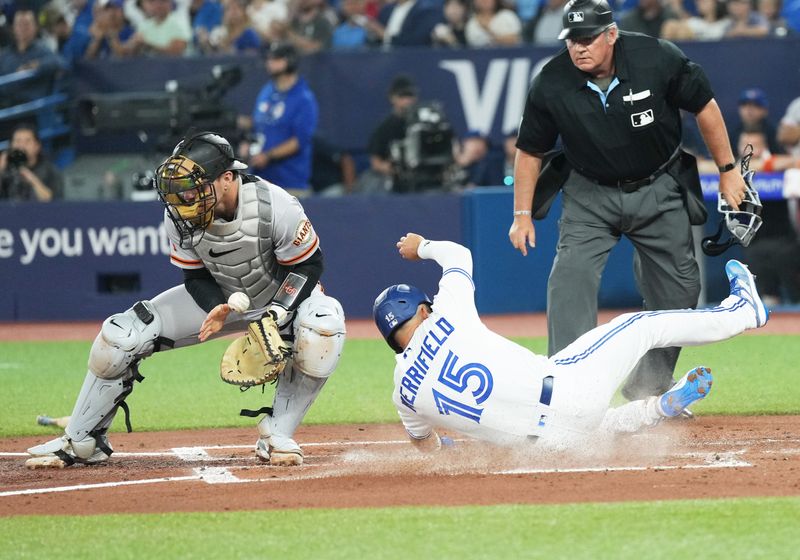 Jun 28, 2023; Toronto, Ontario, CAN; Toronto Blue Jays left fielder Whit Merrifield (15) slides into home plate ahead of the tag from San Francisco Giants catcher Patrick Bailey (14) during the first inning at Rogers Centre. Mandatory Credit: Nick Turchiaro-USA TODAY Sports