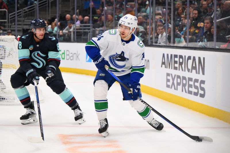 Feb 22, 2024; Seattle, Washington, USA; Vancouver Canucks center Pius Suter (24) plays the puck while defended by Seattle Kraken defenseman Brian Dumoulin (8) during the third period at Climate Pledge Arena. Mandatory Credit: Steven Bisig-USA TODAY Sports