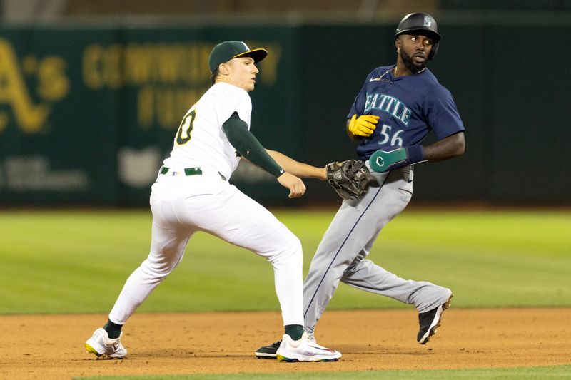 Sep 3, 2024; Oakland, California, USA; Oakland Athletics second baseman Zack Gelof (20) puts the tag on Seattle Mariners left fielder Randy Arozarena (56) to complete a double play during the ninth inning at Oakland-Alameda County Coliseum. Mandatory Credit: D. Ross Cameron-Imagn Images