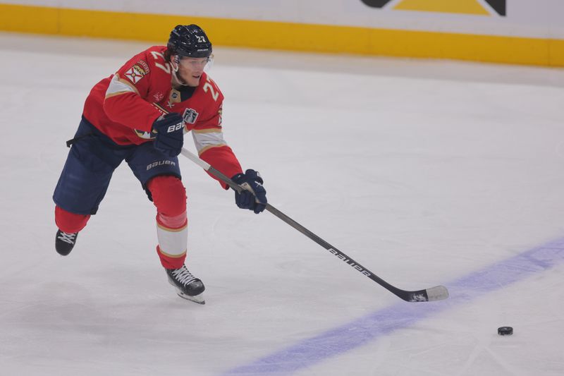 Jun 9, 2025; Sunrise, Florida, USA; Florida Panthers forward Eetu Luostarinen (27) passes the puck  during the second period against the Edmonton Oilers in game three of the 2025 Stanley Cup Final at Amerant Bank Arena. Mandatory Credit: Sam Navarro-Imagn Images