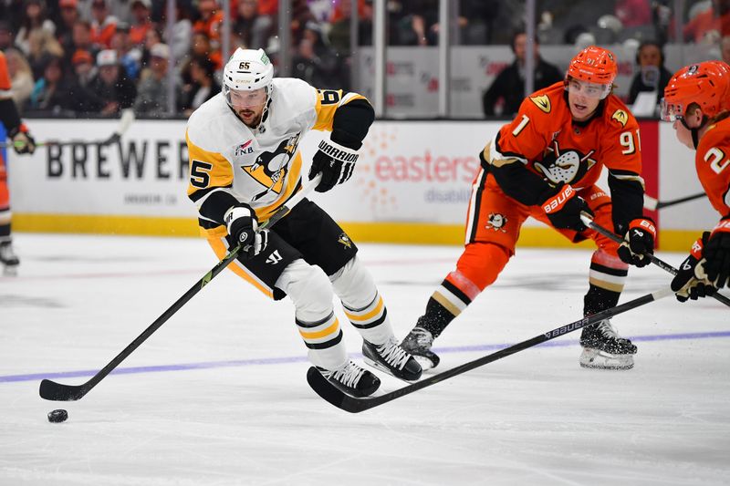 Oct 14, 2025; Anaheim, California, USA; Pittsburgh Penguins defenseman Erik Karlsson (65) moves the puck against Anaheim Ducks center Leo Carlsson (91) during the first period at Honda Center. Mandatory Credit: Gary A. Vasquez-Imagn Images