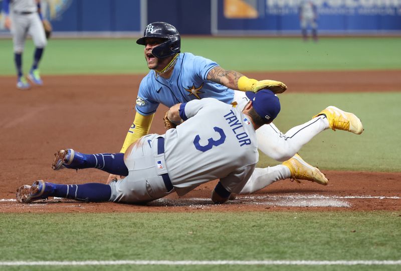 May 28, 2023; St. Petersburg, Florida, USA; Tampa Bay Rays center fielder Jose Siri (22) slides safe into third base as Los Angeles Dodgers infielder Chris Taylor (3)  attempted to tag him out during the fourth inning at Tropicana Field. Mandatory Credit: Kim Klement-USA TODAY Sports