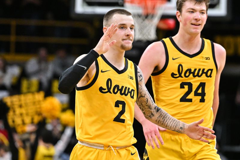 Dec 3, 2024; Iowa City, Iowa, USA; Iowa Hawkeyes guard Brock Harding (2) and forward Pryce Sandfort (24) react against the Northwestern Wildcats during the first half at Carver-Hawkeye Arena. Mandatory Credit: Jeffrey Becker-Imagn Images