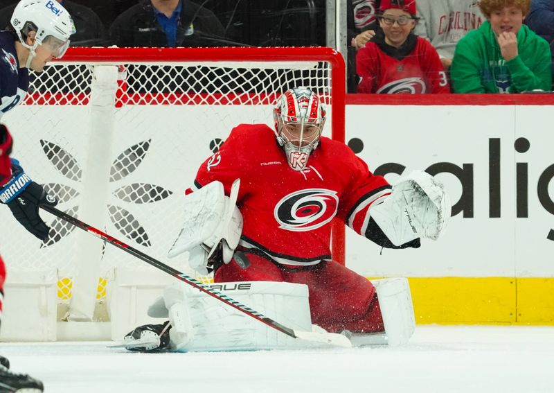 Mar 2, 2024; Raleigh, North Carolina, USA; Carolina Hurricanes goaltender Pyotr Kochetkov (52) makes save against the Winnipeg Jets during the first period at PNC Arena. Mandatory Credit: James Guillory-USA TODAY Sports