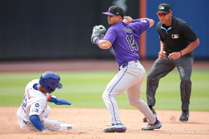 Jul 14, 2024; New York City, New York, USA; Colorado Rockies shortstop Ezequiel Tovar (14) attempts to turn a double play after forcing out New York Mets shortstop Francisco Lindor (12) at second base during the eighth inning at Citi Field. Mandatory Credit: Vincent Carchietta-USA TODAY Sports