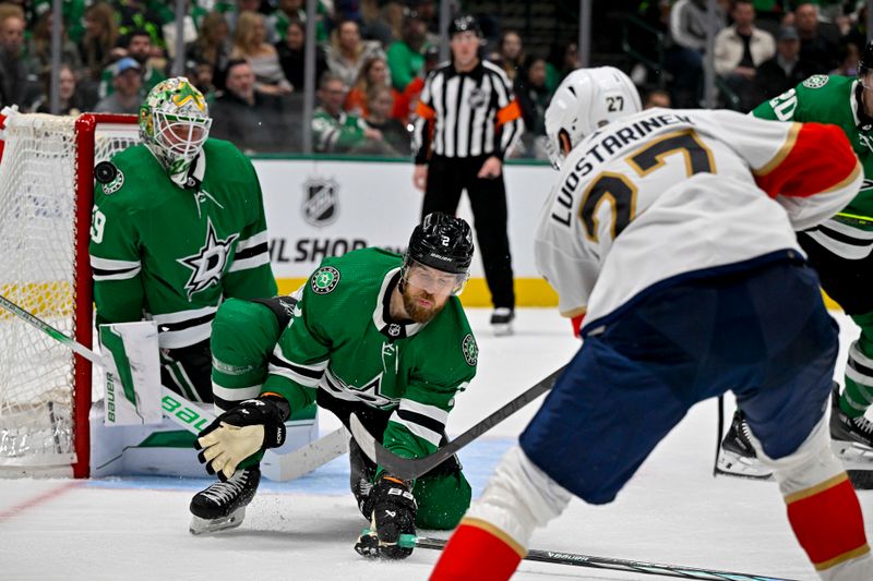 Mar 12, 2024; Dallas, Texas, USA; Florida Panthers center Eetu Luostarinen (27) hits the crossbar with the puck as he shoots past Dallas Stars defenseman Jani Hakanpaa (2) and goaltender Jake Oettinger (29) during the third period at the American Airlines Center. Mandatory Credit: Jerome Miron-USA TODAY Sports