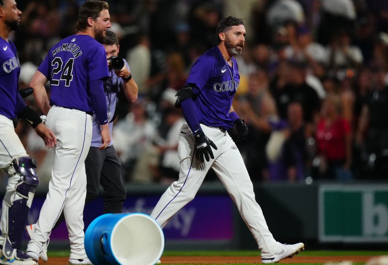 Jul 1, 2024; Denver, Colorado, USA; Colorado Rockies outfielder Jake Cave (11) celebrates his walk off RBI in the tenth inning against the Milwaukee Brewers at Coors Field. Mandatory Credit: Ron Chenoy-USA TODAY Sports