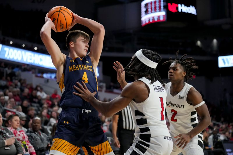 Dec 19, 2023; Cincinnati, Ohio, USA; Merrimack Warriors guard Jordan Derkack (4) looks to pass against Cincinnati Bearcats guard Day Day Thomas (1) and guard Jizzle James (2) in the second half at Fifth Third Arena. Mandatory Credit: Aaron Doster-USA TODAY Sports