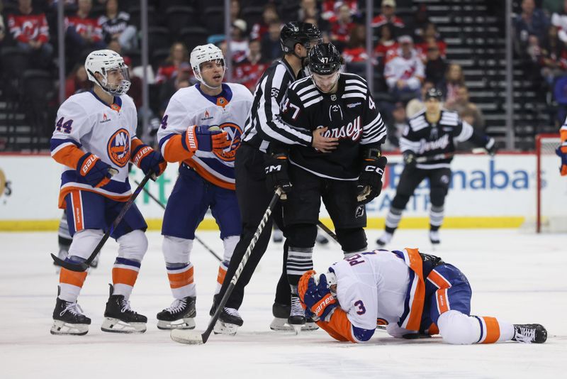 Apr 13, 2025; Newark, New Jersey, USA; New York Islanders defenseman Adam Pelech (3) lies on the ice after being hit in the head by New Jersey Devils center Paul Cotter (47) during the second period at Prudential Center. Mandatory Credit: Ed Mulholland-Imagn Images