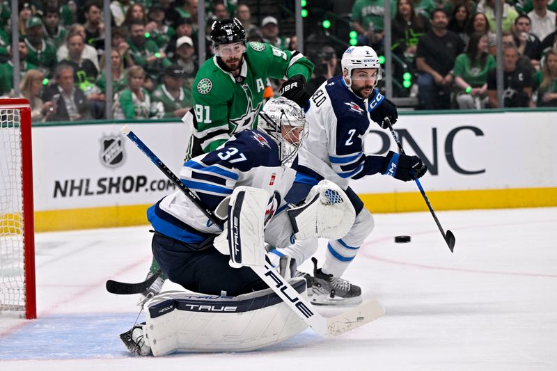 May 11, 2025; Dallas, Texas, USA; Winnipeg Jets goaltender Connor Hellebuyck (37) stops a shot as defenseman Dylan DeMelo (2) and Dallas Stars center Tyler Seguin (91) look for the rebound during the second period in game three of the second round of the 2025 Stanley Cup Playoffs at American Airlines Center. Mandatory Credit: Jerome Miron-Imagn Images