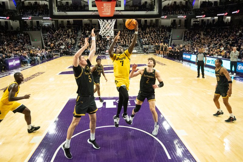 Feb 28, 2025; Evanston, Illinois, USA; Northwestern Wildcats center Keenan Fitzmorris (5) defends Iowa Hawkeyes forward Seydou Traore (7) during the second half at Welsh-Ryan Arena. Mandatory Credit: David Banks-Imagn Images