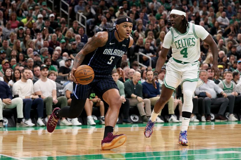 BOSTON, MASSACHUSETTS - APRIL 20: Paolo Banchero #5 of the Orlando Magic drives the ball against Jrue Holiday #4 of the Boston Celtics in Game One of the Eastern Conference First Round NBA Playoffs at TD Garden on April 20, 2025 in Boston, Massachusetts. NOTE TO USER: User expressly acknowledges and agrees that, by downloading and or using this photograph, User is consenting to the terms and conditions of the Getty Images License Agreement. (Photo by Maddie Meyer/Getty Images)