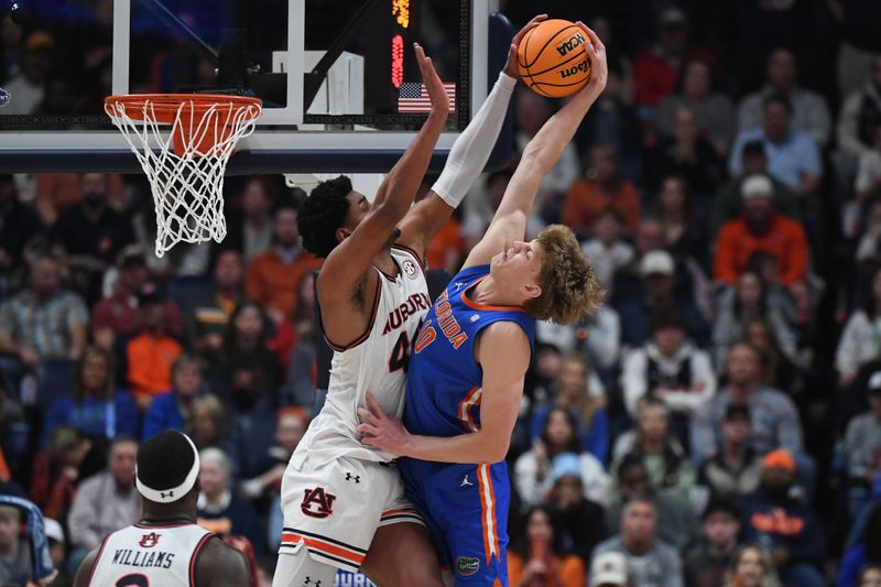 Mar 17, 2024; Nashville, TN, USA; Auburn Tigers center Dylan Cardwell (44) blocks Florida Gators forward Thomas Haugh (10) in the first half in the SEC Tournament championship game at Bridgestone Arena. Mandatory Credit: Christopher Hanewinckel-USA TODAY Sports