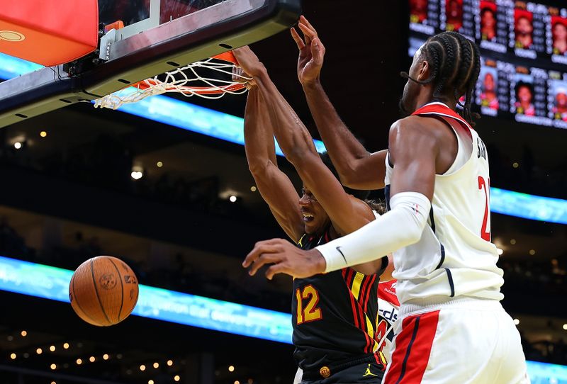 ATLANTA, GEORGIA - NOVEMBER 15:  De'Andre Hunter #12 of the Atlanta Hawks dunks against Corey Kispert #24 and Alexandre Sarr #20 of the Washington Wizardsduring the fourth quarter of the Emirates NBA Cup game at State Farm Arena on November 15, 2024 in Atlanta, Georgia.  NOTE TO USER: User expressly acknowledges and agrees that, by downloading and/or using this photograph, user is consenting to the terms and conditions of the Getty Images License Agreement.  (Photo by Kevin C. Cox/Getty Images)