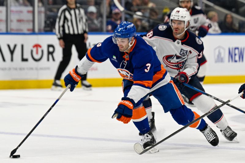 Nov 2, 2025; Elmont, New York, USA; New York Islanders defenseman Adam Pelech (3) controls the puck at the blue line defended by Columbus Blue Jackets center Boone Jenner (38) during the third period at UBS Arena. Mandatory Credit: Dennis Schneidler-Imagn Images