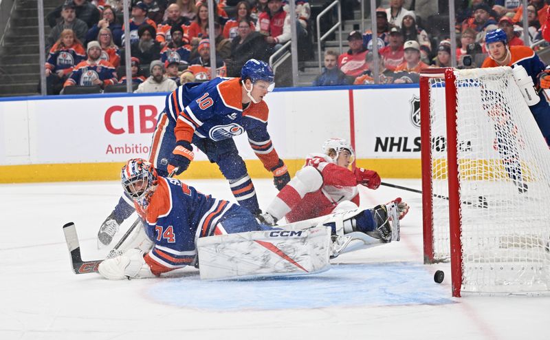 Dec 11, 2025; Edmonton, Alberta, CAN; Edmonton Oilers goalie Stuart Skinner (74) looks for the puck with Edmonton Oilers (10) center Trent Frederic as Detroit Red Wings defenseman Simon Edvinsson (77) slides past during the second period at Rogers Place. Mandatory Credit: Walter Tychnowicz-Imagn Images