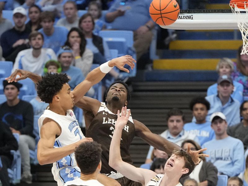 Nov 12, 2023; Chapel Hill, North Carolina, USA; North Carolina Tar Heels guard Seth Trimble (7) passes the ball as Lehigh Mountain Hawks guard Keith Higgins Jr. (13) and center Henri Adiassa (32) and guard Ben Knostman (2) defend in the first half at Dean E. Smith Center. Mandatory Credit: Bob Donnan-USA TODAY Sports