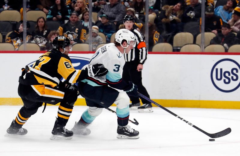 Jan 15, 2024; Pittsburgh, Pennsylvania, USA; Seattle Kraken defenseman Will Borgen (3) skates with the puck against Pittsburgh Penguins right wing Rickard Rakell (67) during the third period at PPG Paints Arena. Mandatory Credit: Charles LeClaire-USA TODAY Sports