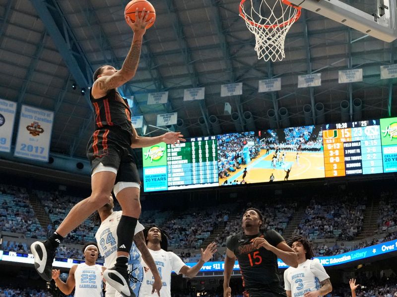 Mar 1, 2025; Chapel Hill, North Carolina, USA;  Miami (Fl) Hurricanes guard Matthew Cleveland (0) shoots as North Carolina Tar Heels forward Jae'Lyn Withers (24) defends in the first half at Dean E. Smith Center. Mandatory Credit: Bob Donnan-Imagn Images