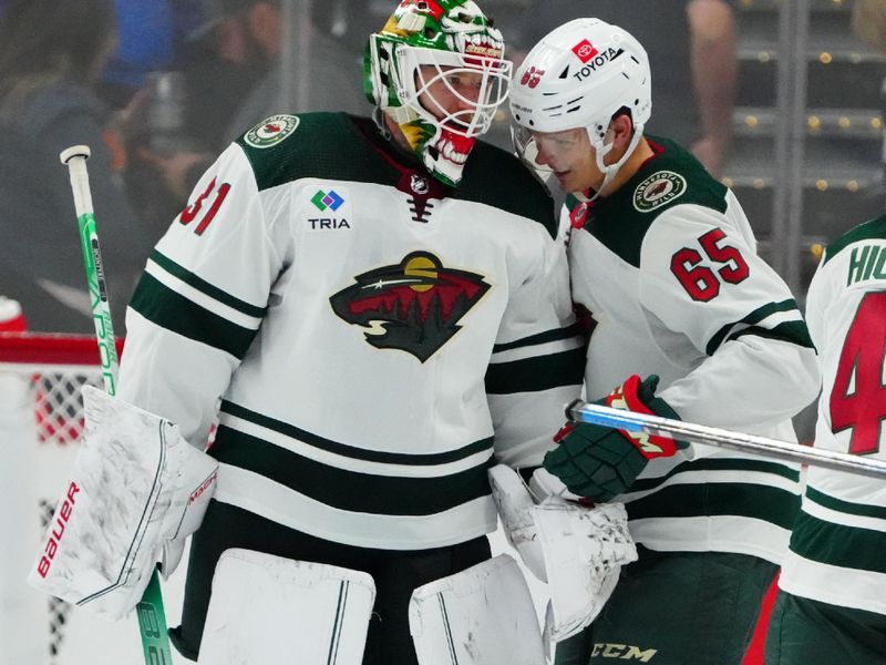 Sep 27, 2022; Denver, Colorado, USA; Minnesota Wild goalie Zan McIntyre (31) and right wing Vladislav Firstov (65) celebrate defeating the Colorado Avalanche at Ball Arena. Mandatory Credit: Ron Chenoy-USA TODAY Sports