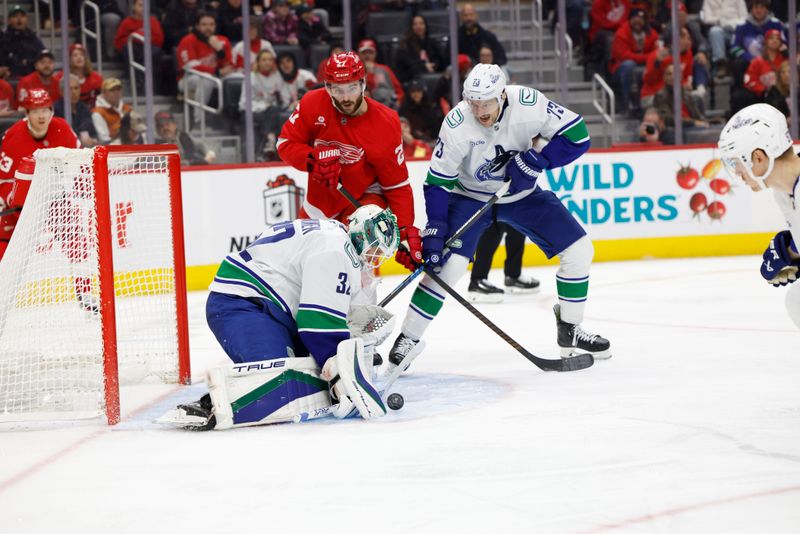 Dec 1, 2024; Detroit, Michigan, USA;  Vancouver Canucks goaltender Kevin Lankinen (32) makes a save in front of defenseman Vincent Desharnais (73) and Detroit Red Wings center Michael Rasmussen (27) in the second period at Little Caesars Arena. Mandatory Credit: Rick Osentoski-Imagn Images