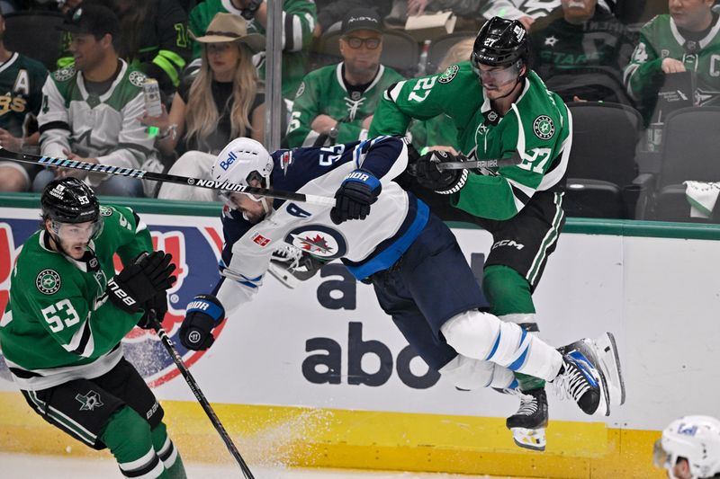 May 17, 2025; Dallas, Texas, USA; Dallas Stars left wing Mason Marchment (27) checks Winnipeg Jets center Mark Scheifele (55) during the second period in game six of the second round of the 2025 Stanley Cup Playoffs at American Airlines Center. Mandatory Credit: Jerome Miron-Imagn Images
