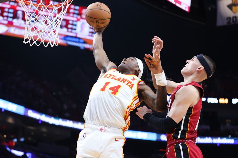 MIAMI, FLORIDA - FEBRUARY 26: Terance Mann #14 of the Atlanta Hawks dunks the ball against Tyler Herro #14 of the Miami Heat during the second quarter of the game at Kaseya Center on February 26, 2025 in Miami, Florida. NOTE TO USER: User expressly acknowledges and agrees that, by downloading and or using this photograph, User is consenting to the terms and conditions of the Getty Images License Agreement. (Photo by Megan Briggs/Getty Images)